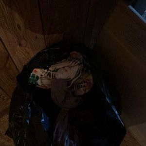 A garbage bag full of name brand clothes/shoes